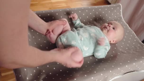 Mãe massageando suas pernas de bebê, fazendo exercícios para músculos — Vídeo de Stock