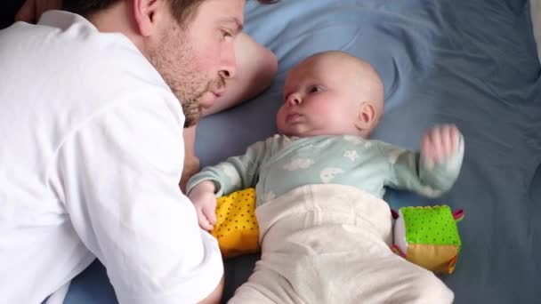 Vader praat met zijn baby, speelt, brengt tijd samen door. — Stockvideo