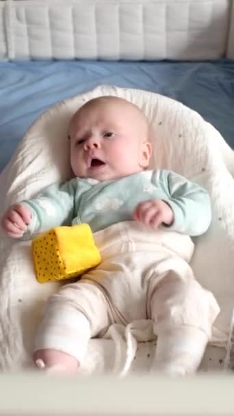 Niño jugando con un juguete en una cama en casa — Vídeos de Stock