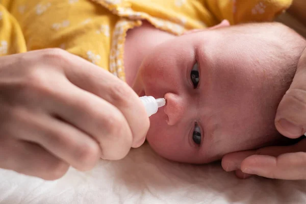 Mam stopt druppels in de neus van het kind. — Stockfoto