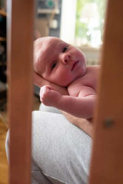 Baby pige ser på kameraet hviler på hans far knæ - Stock-foto