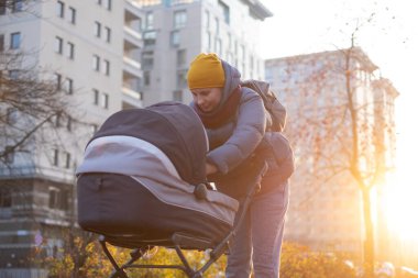 Yürürken bebek arabasıyla mutlu bir anne.