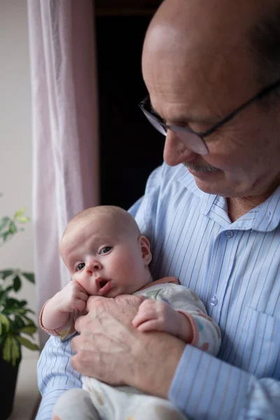 Grandfather holding a beautiful newborn baby girl — Stock Photo, Image