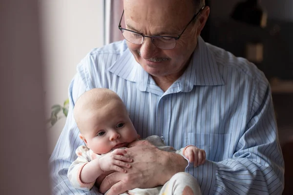Дедушка держит красивую новорожденную девочку — стоковое фото