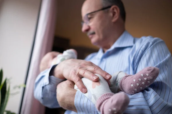 Grandfather holding a beautiful newborn baby girl — Stock Photo, Image