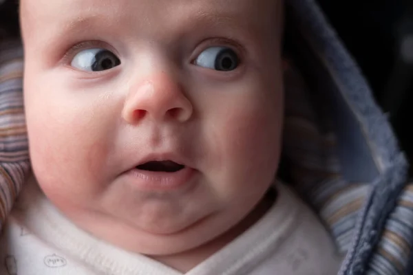 Tiga bulan bayi melihat ke samping dengan halus terkejut ekspresi. — Stok Foto