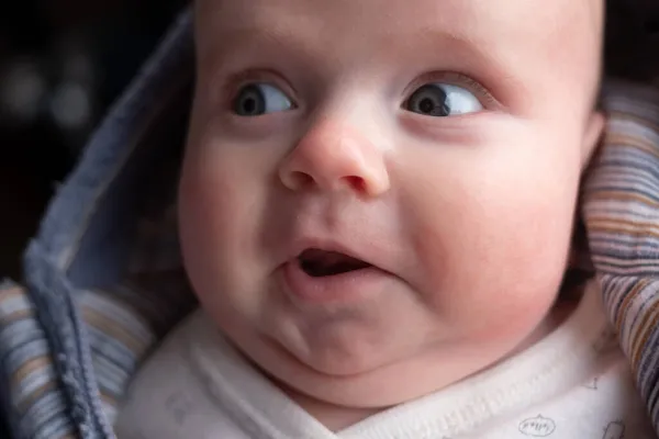 Trois mois bébé regarder de côté avec finny expression surprise. — Photo