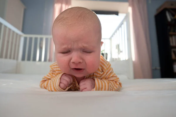 Potret menangis bayi perempuan berbaring sendirian di tempat tidur. — Stok Foto