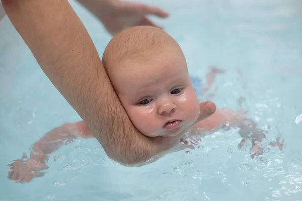 Caucásico 2 meses bebé haciendo ejercicio en la piscina — Foto de Stock