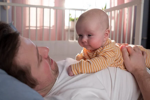 Молодой отец проводит время со своей новорожденной дочкой в постели — стоковое фото