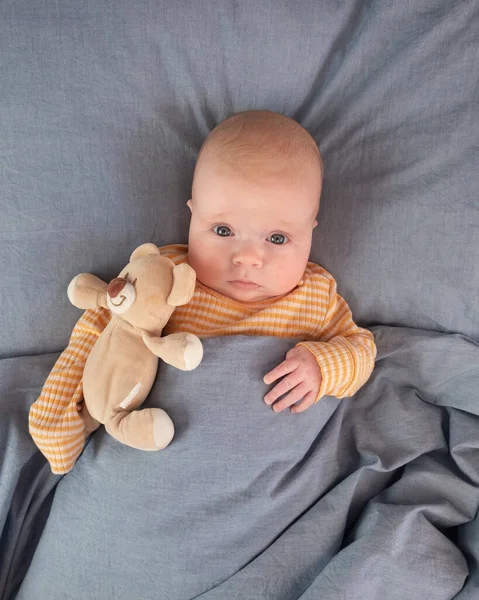 Funny caucasian baby lying on the bed. — Stock Photo, Image