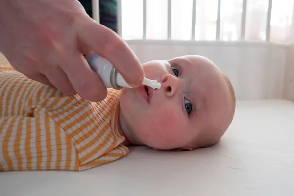 Mother cleaning noe of her baby with nasal drops — Stock Photo, Image