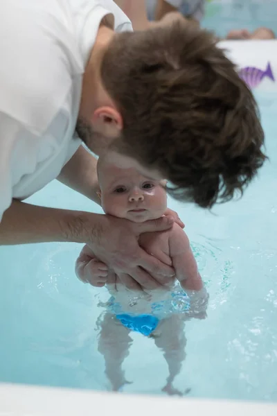 Caucásico 2 meses bebé haciendo ejercicio en la piscina — Foto de Stock