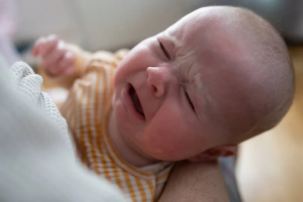 Portrait of crying baby girl lying alone on bed. — Stock Photo, Image