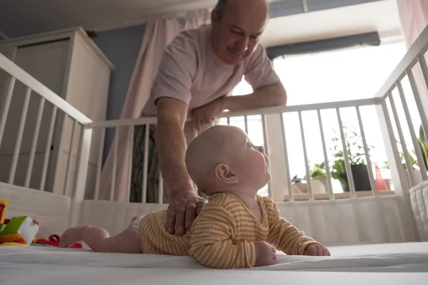 Cheerful senior grandfather playing with grandson at the bedroom — Stock Photo, Image