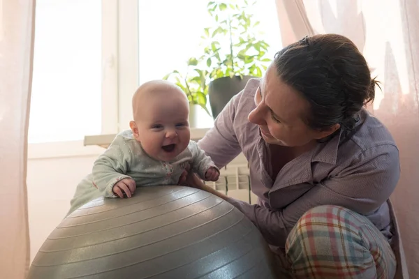 Mother and her baby girl having fun with gymnastic ball. — Stock Photo, Image