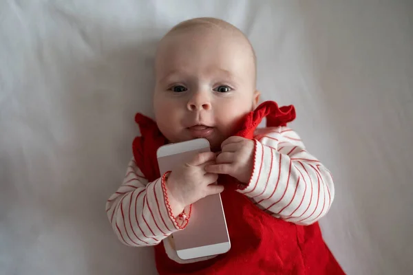 Bébé jouer woth téléphone tenant pour la première fois dans sa vie. — Photo