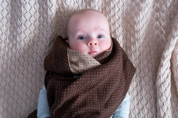 Lindo bebé con grandes ojos azules con un sombrero y una bufanda de punto enorme — Foto de Stock