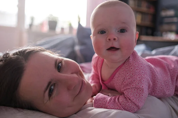 Gelukkig liefdevolle Kaukasische moeder besteden tijd, spelen met baby meisje. Stockafbeelding