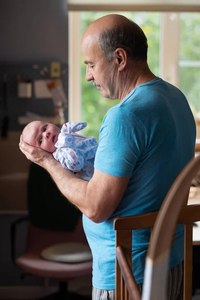 Grandfather holding a caucasian newborn baby girl — Stock Photo, Image