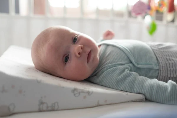 Baby lies on a special pillow against spitting up — Stock Photo, Image