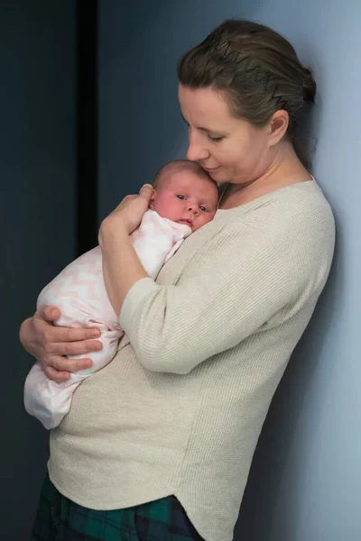 Caring young mother hold lean to chest newborn. Relax enjoy tender family moment at home lizenzfreie Stockbilder