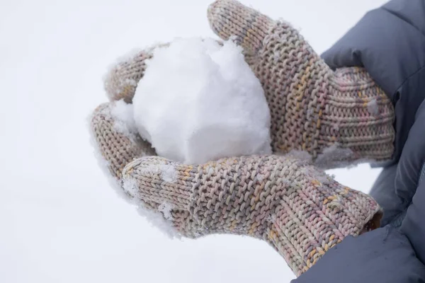 Bola de nieve en la mano de una mujer. listo para la lucha contra la nieve —  Fotos de Stock