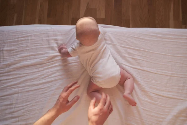 Caucasian baby crawling to the edge of the bed. — Stock Photo, Image