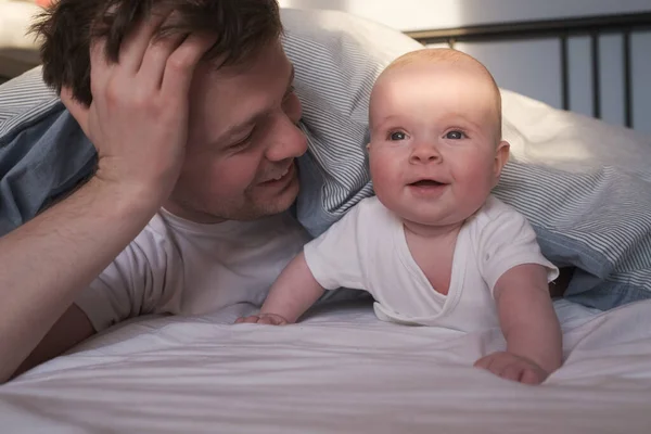 白人の父とかわいいです子供一緒にベッドで休む. — ストック写真