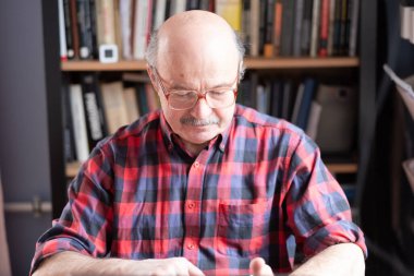 Evde dizüstü bilgisayarı olan gözlüklü son sınıf öğrencisi internette arama yapıyor.