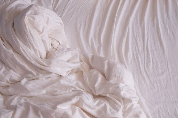 Красивые белые сверкающие смятые ткани на кровати. — стоковое фото
