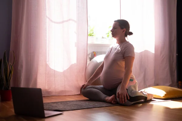 Zwangere vrouw op fitness mat, training thuis Rechtenvrije Stockfoto's