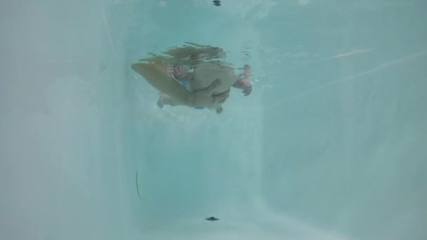 Kaukasische baby jongen duiken onder het water. — Stockvideo