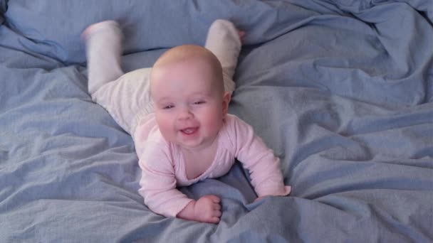 Καυκάσιο μωρό ξαπλωμένο στο κρεβάτι γελώντας. — Αρχείο Βίντεο