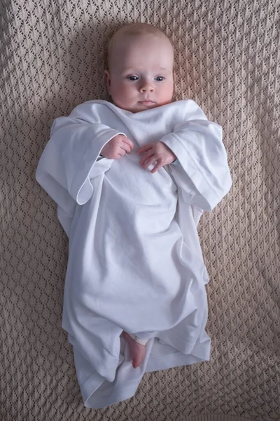 Bebé caucásico vestido con camiseta de padre acostado en la cama — Foto de Stock