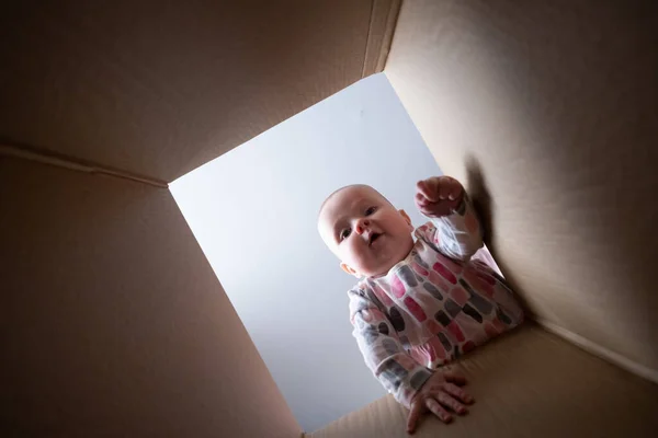 Happy baby into parcel cardboard box and smiling. — Stock Photo, Image