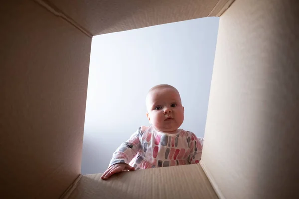 Happy baby into parcel cardboard box and smiling. — Stock Photo, Image