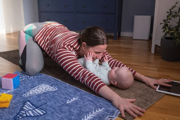 Madre con bebé hacen yoga en casa para ser fuerte y saludable — Foto de Stock