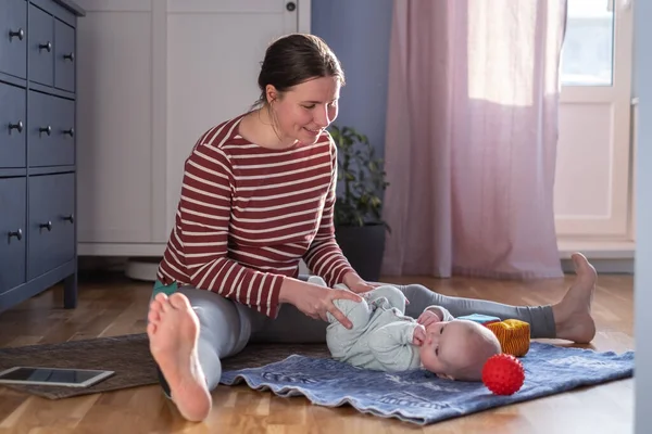 Bebekli anne güçlü ve sağlıklı olmak için evde yoga yapıyor. Telifsiz Stok Fotoğraflar