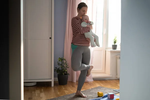 Мати з дитиною робить йогу вдома міцною і здоровою — стокове фото