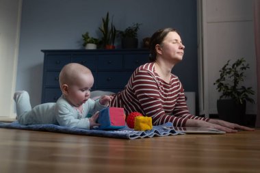 Bebekli anne güçlü ve sağlıklı olmak için evde yoga yapıyor.