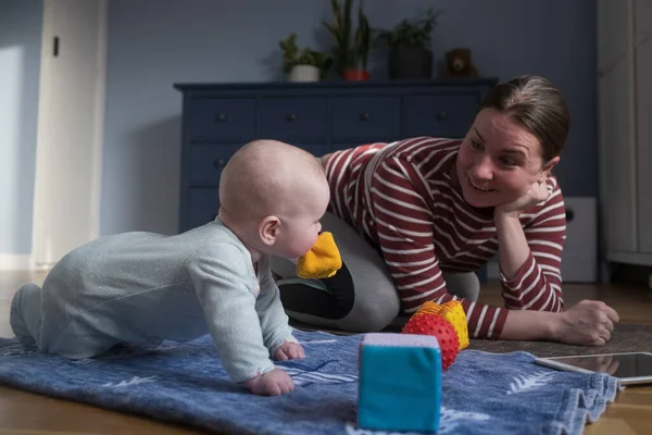 Beyaz anne ve bebek güçlü ve sağlıklı olmak için evde yoga yapıyorlar.,