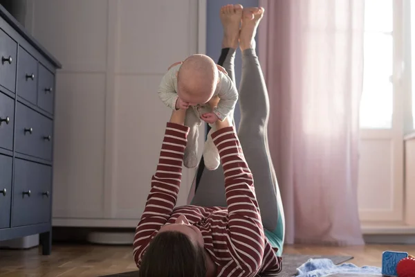 Caucasian mother with baby make yoga at home to be strong and healthy, — Stock Photo, Image