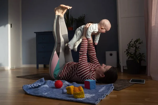 Caucasian mother with baby make yoga at home to be strong and healthy, — Stock Photo, Image