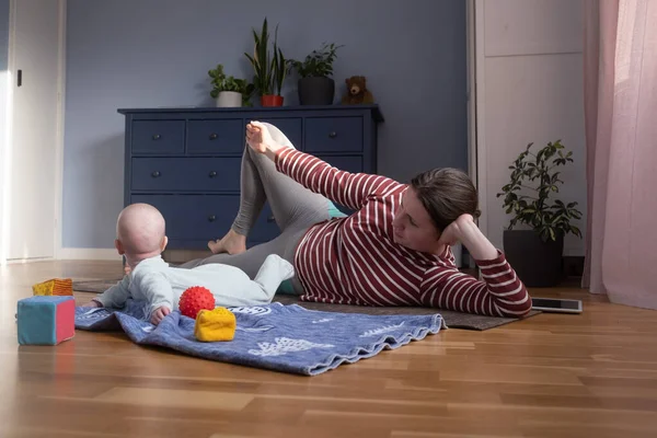 Caucasian mother with baby make yoga at home to be strong and healthy, — Stock Photo, Image