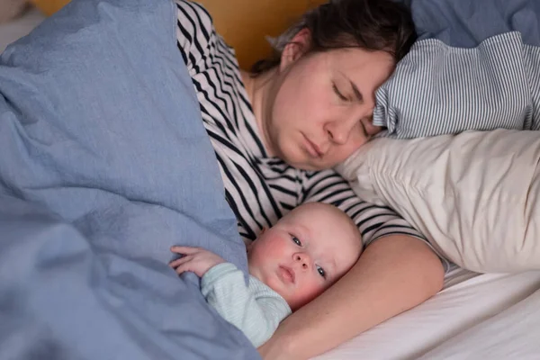 Kaukasia ibu muda dan bayi kecilnya yang lucu tidur di tempat tidur — Stok Foto