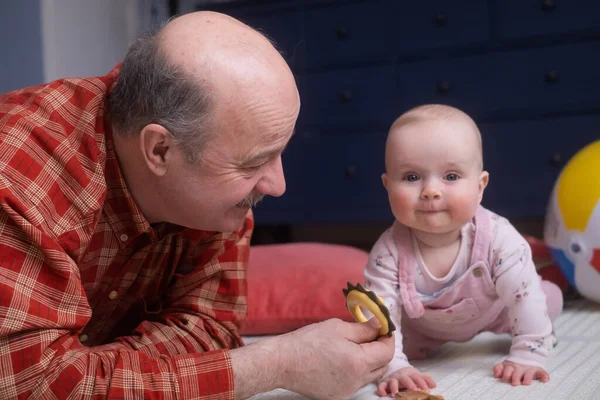 Senior man playing with his grandaughter at home — Stock Photo, Image
