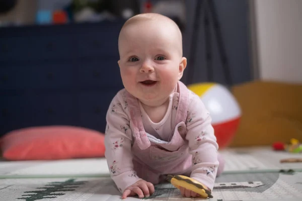 Bebé caucásico de seis meses en el suelo con un juguete — Foto de Stock