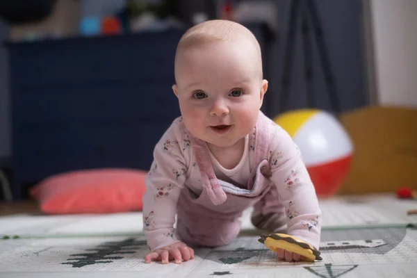 Six months old caucasian baby on the floor with a toy — Stock Photo, Image