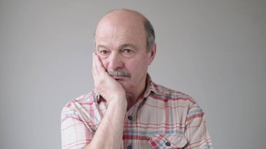 Sıkıcı, yaşlı, İspanyol bir adamın yanağında el ele tutuşması kasvetli ve hüzünlü bir ifade. Zaman tükeniyor, çok yorgunum. Stüdyo çekimi